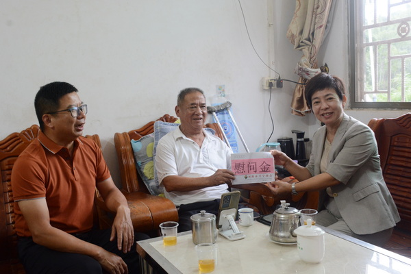 图为理事长为残疾人送上慰问金_调整大小.JPG